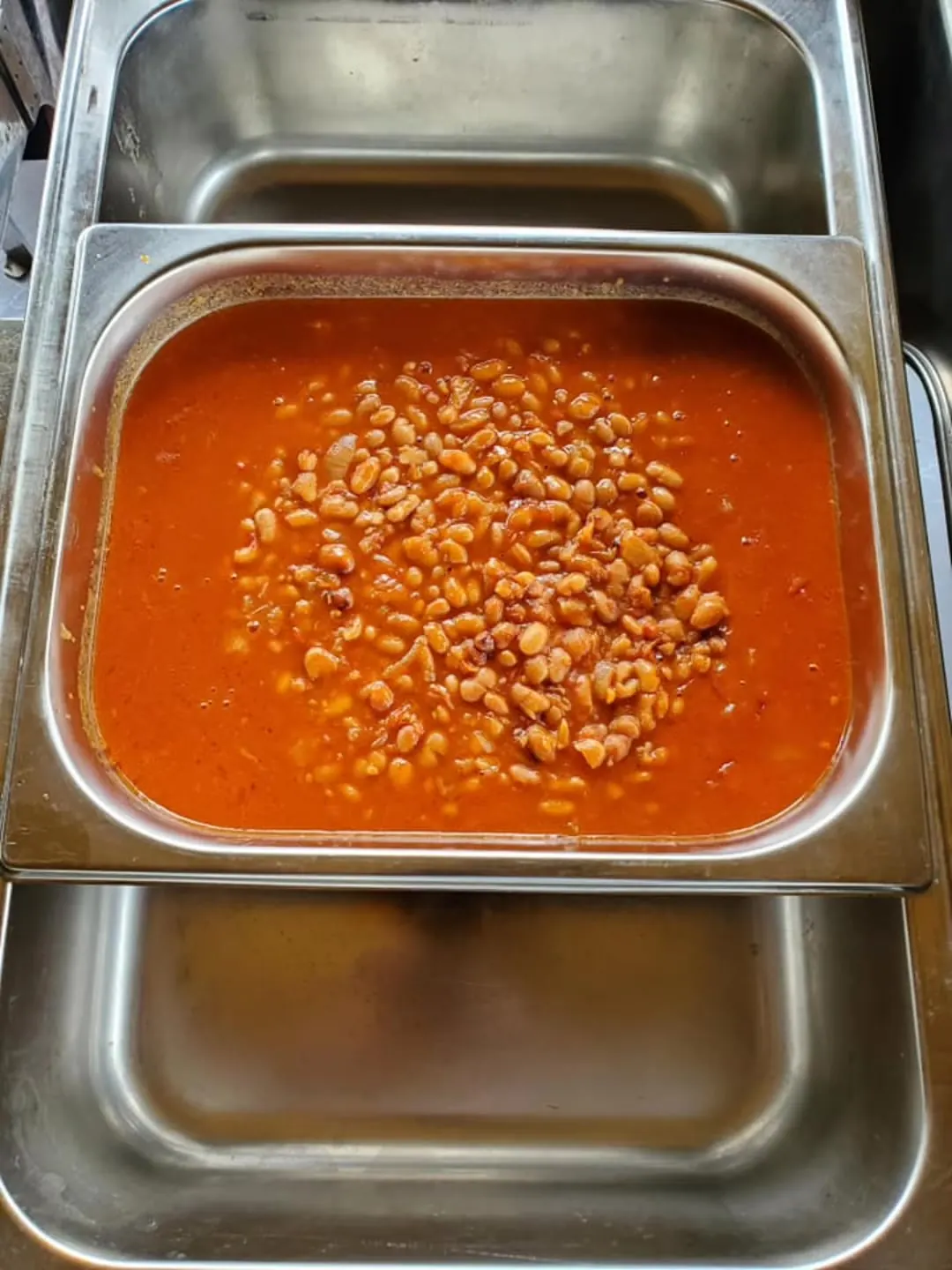 Tray of beans in tomato sauce at the buffet