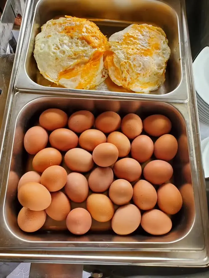 Chafing dishes of fried and boiled eggs at the breakfast buffet